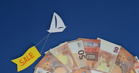 A ship flies with a flag sale  boarded a planet made of euro banknotes.