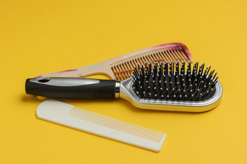 Combs on yellow background. Beauty minimalistic concept. Hair care.