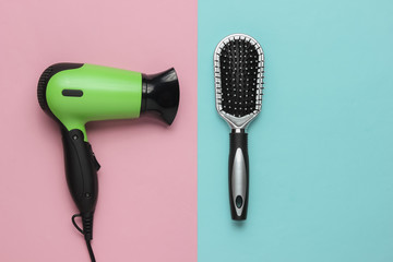Hair care. Beauty studio shot. Hair dryer, comb on  pink blue background. Top view