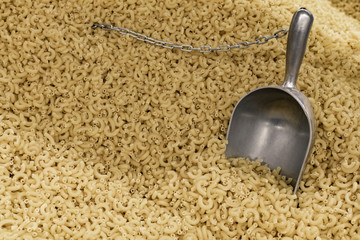 raw macaroni supermarket food background view with spoon on weight 