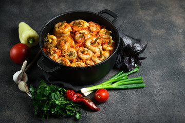 Stuffed peppers with rice, meat and spices in a dark pan on a dark background. Copy space.