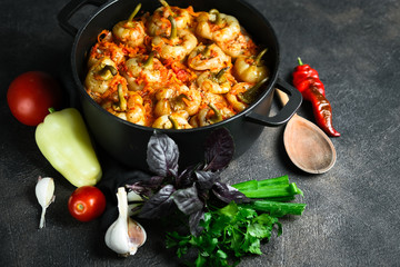 Stuffed peppers with rice, meat and spices in a dark pan on a dark background. Copy space.
