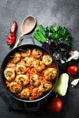 Stuffed peppers with rice, meat and spices in a dark pan on a dark background top view. Copy space.