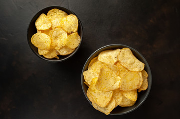 potato chips in two bowls, beer snacks on a stone background