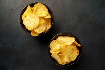 potato chips in two bowls, beer snacks on a stone background