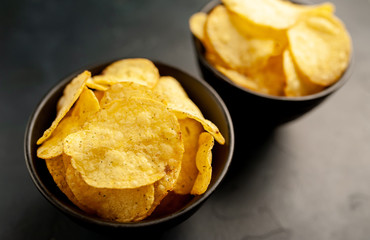 potato chips in two bowls, beer snacks on a stone background