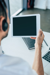 selective focus of call center operator holding digital tablet with blank screen