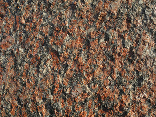 Rough uneven surface of red granite close up. Natural stone background.