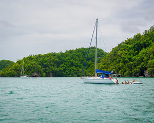 Luxury boat anchored close to exotic tropical island. Panoramic landscape view of Los Haitises natural park,Samana peninsula in Dominican republic.