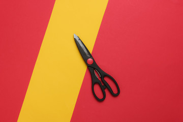 Kitchen scissors on a colored paper background. Top view