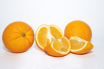 Fresh oranges with many slices on white background