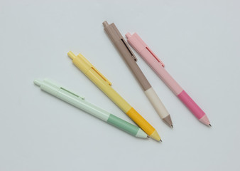 A lot of colored pens close-up on a white background.