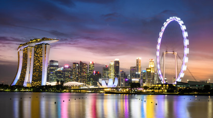 Stunning view of the illuminated skyline of Singapore during a beautiful and dramatic sunset. Singapore is an island city-state off southern Malaysia.