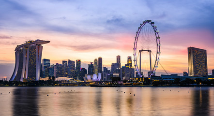 Atemberaubende Aussicht auf die beleuchtete Skyline von Singapur während eines wunderschönen und dramatischen Sonnenuntergangs. Singapur ist ein Insel-Stadtstaat im Süden Malaysias.
