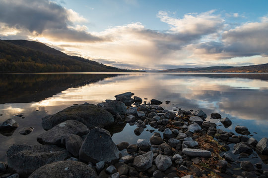 An autumnal image of the calm waters of Loch Rannoch in afternoon sunlight, Perth and Kinross, Scotland.