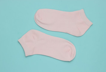 Pink socks on blue background. Minimalism fashion concept. Pastel color trend.