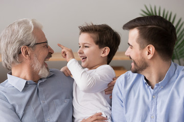 Laughing grandfather hugging grandson, three generations of men