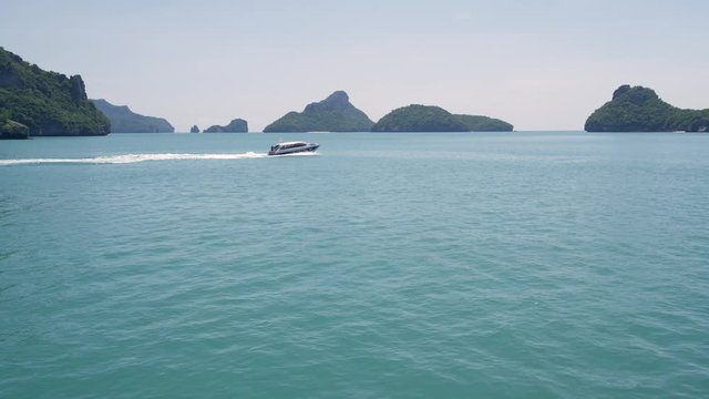 Group of Islands in ocean at Ang Thong National Marine Park near touristic Samui paradise tropical resort. Archipelago in the Gulf of Thailand. Idyllic turquoise sea natural background with boat.