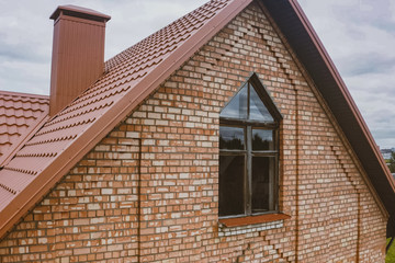 Beautiful pink brick brick house and orange roof. Corrugated met
