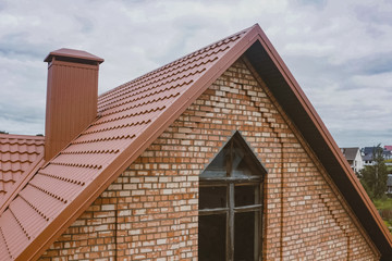 Beautiful pink brick brick house and orange roof. Corrugated met