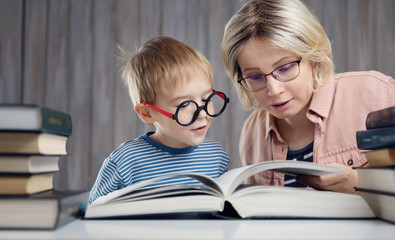 five years old child reading a book at home with mother