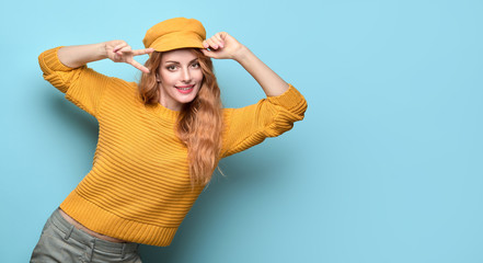 Easy-going Woman happy smiling shows peace sign in Stylish fashion orange colored outfit. Beautiful...