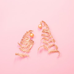 Christmas tree of painted golden leaves fern on pink paper background