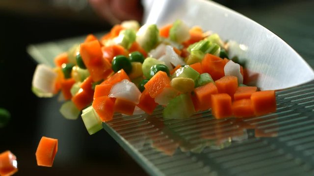 Diced vegetables tossed of cutting board in slow motion