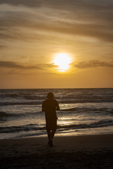 Fototapeta na wymiar silhouette of a man on the beach at sunset