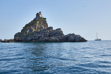 Small stone Islands in the sea with a small chapel on top.