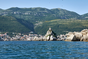 Small stone Islands in the sea with a small chapel on top.