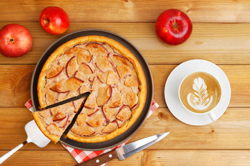 Homemade pie with apple, cinnamon and yogurt topping on wooden table. Top view.