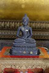 Ancient stone statue of Buddha sitting in lotus position.