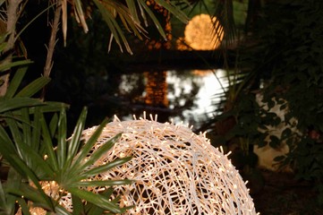 Naklejka premium big light balls next to the lake among green vegetation at sunset 