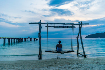 Teluk Keke Beach, Besur, Perhentian Islands, Malaysia; 17-May-2019; a lady enjoying a swing by the sea at sunset, Teluk Keke Beach, Besur, Perhentian Islands, Malaysia