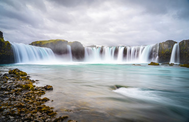 Godafoss waterfall, foggy from waterspray on a cloudy morning, Iceland