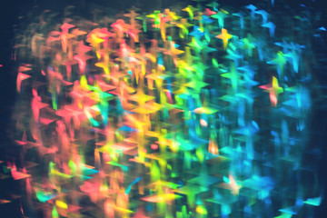 Multicolor blue and red neon lights star flares and rainbow glitter over confetti background. Bokeh lens flare glow. Festive backdrop