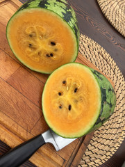 yellow watermelon on wooden table with knife