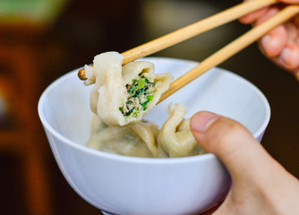 Chopsticks Pick Up an Opened Chinese Dumpling from a Bowl