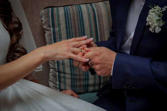 Marriage hands with rings. The bride puts a ring on the finger of the groom during the wedding ceremony. The bride and groom exchange rings in wedding day. Photo closeup