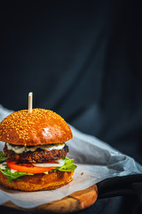 Freshly made forest burger with rucola, onions, grilled portobello and garlic souce on dark...