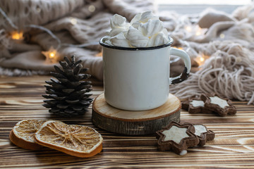 Traditional Christmas drink hot chocolate with marshmallows with anise stars and cinnamon sticks on rustic wooden table with festive decor and warm blanket. Hygge home interior.