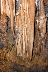 Stalactites in limestone caves visited by speleologists