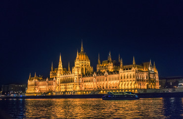 Fototapeta na wymiar Budapest, Hungary - August 29, 2019: Hungarian Parliament building and Danube River in the Budapest city at night. A sample of neo-gothic architecture, Budapest's tourist attraction