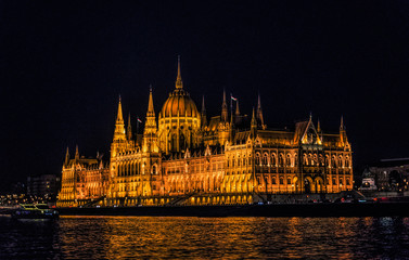Obraz premium Budapest, Hungary - August 29, 2019: Hungarian Parliament building and Danube River in the Budapest city at night. A sample of neo-gothic architecture, Budapest's tourist attraction