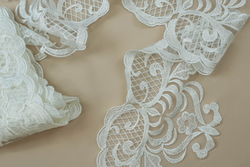 Texture lace fabric. lace on white background studio. thin fabric made of yarn or thread. a background image of ivory-colored lace cloth. White lace on beige background.