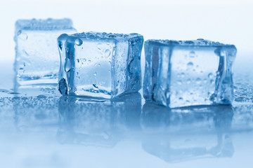 Ice cubes square with drops water clean on blue background