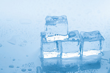 Ice cubes square with drops water clean on blue background