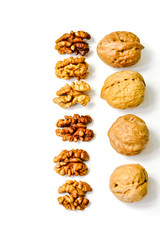 Walnut kernels and whole walnut lined up isolated on white background. Copy Space. Close up. Healthy eating concept.