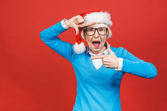 Senior Aged Grey-haired Woman Wearing Christmas Santa Hat Over Isolated Red Background Very Happy And Excited, Having Fun, Smiling.